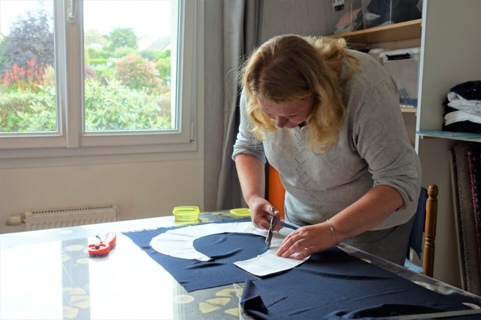 Béatrice à l’œuvre, ici en train de découper le tissu d’une jupe.